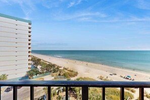 Blick auf einen Strand vom Balkon, mit Blick auf Sand und Meer.
