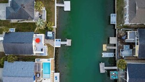 A residential area with houses, a swimming pool, and docks extending into a green body of water. - Casa del Mare Beach House (North Myrtle Beach)