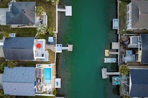A residential area with houses, a swimming pool, and docks extending into a green body of water. - Casa del Mare Beach House (North Myrtle Beach)