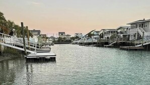 A waterfront property with a dock, multiple houses, and a calm water body. - Casa del Mare Beach House (North Myrtle Beach)