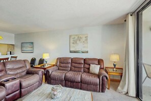 Ein Hotelzimmer mit Ledersofa, Couchtisch, Lampe und einem Gemälde an der Wand.