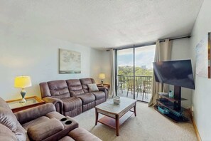 A living room with a sofa, a coffee table, and a TV. - Holiday Towers Unit 501 (Myrtle Beach)