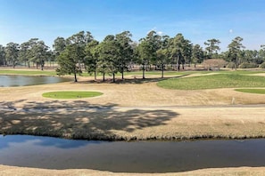 A golf course with sand bunkers, a pond, and trees. - Wild Iris Unit 202 Condo (Myrtle Beach)