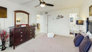 A room with a ceiling fan, a dresser, a sofa, and a mirror. - Holiday Towers Unit 1108 (Myrtle Beach)