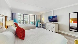 A hotel room with two beds, a television, a desk, and a balcony with a view. - Grande Cayman Unit 413 (Myrtle Beach)