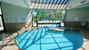 En indendørs swimmingpool med sikkerhedsskilte, uhindret udsigt til det fri og flisegulv.
