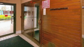 Une porte de sortie avec un panneau indiquant que l’entrée est interdite aux personnes de moins de 18 ans, sauf si elles sont accompagnées.