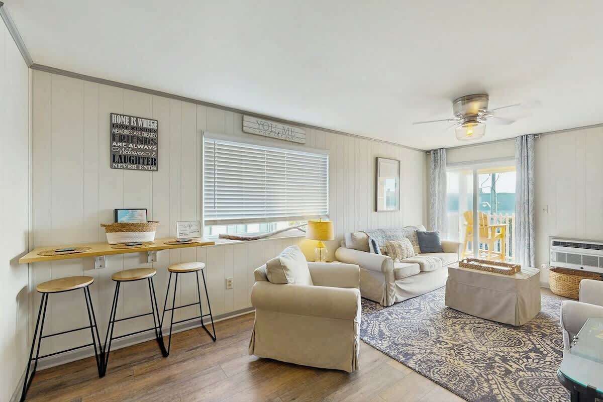 A cozy living room with a sofa, a coffee table, and a bar area with stools.