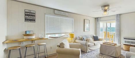 A cozy living room with a sofa, a coffee table, and a bar area with stools.