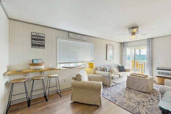 A cozy living room with a sofa, a coffee table, and a bar area with stools. - Blessings from Above at Inlet Villas (North Myrtle Beach)
