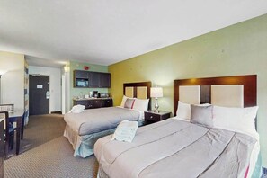 A hotel room with two beds, a desk, and a kitchenette. - Landmark Resort Unit 920 (Myrtle Beach)