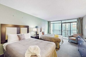 A hotel room with two beds, a sofa, a dresser, and a balcony with a view. - Landmark Resort Unit 920 (Myrtle Beach)