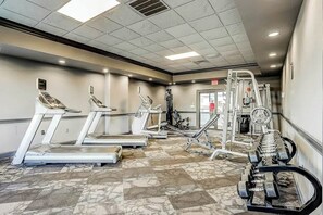 A gym with treadmills, elliptical machines, and weightlifting equipment. - Bluewater Resort 1006 (Myrtle Beach)