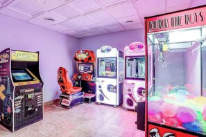 Eine Reihe von Spielautomaten in einem Raum mit violetten Wänden und einer Decke mit eingelassener Beleuchtung.