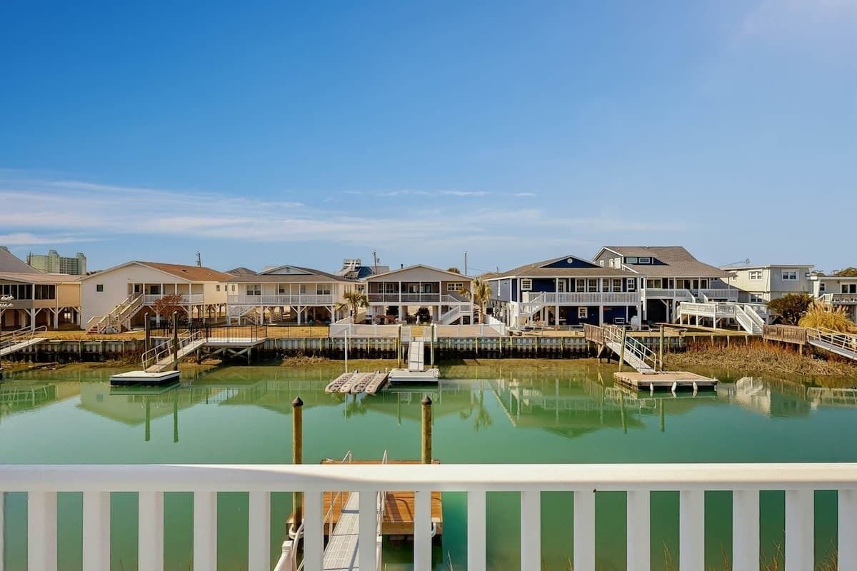 A waterfront property with multiple buildings, docks, and a clear sky.