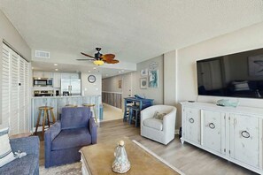 A spacious living area with a sofa, a coffee table, and a television on a cabinet. - Verandas Unit 803 Condo (North Myrtle Beach)