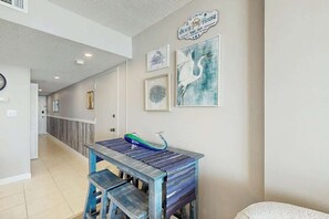 A hallway with a wooden bench, a wall-mounted sink, and framed artwork. - Verandas Unit 803 Condo (North Myrtle Beach)