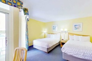 A hotel room with two beds, a chair, and a window with curtains. - Bay Watch Resort 1410 (North Myrtle Beach)