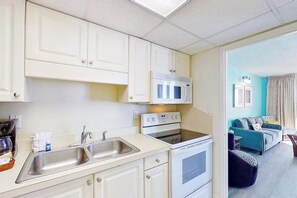 Eine kleine Küche mit Mikrowelle, Herd und Spüle.