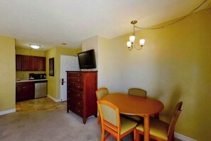 A compact living space with a dining area, kitchenette, and a television. - Ocean Park Resort 0322/0324 Combo (Myrtle Beach)