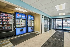 A lobby area with vending machines, a reception desk, and a view of the outside. - Ocean Park Resort 0322/0324 Combo (Myrtle Beach)