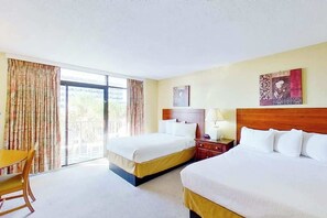 Ein Hotelzimmer mit zwei Betten, einem Schreibtisch und einem Sessel.