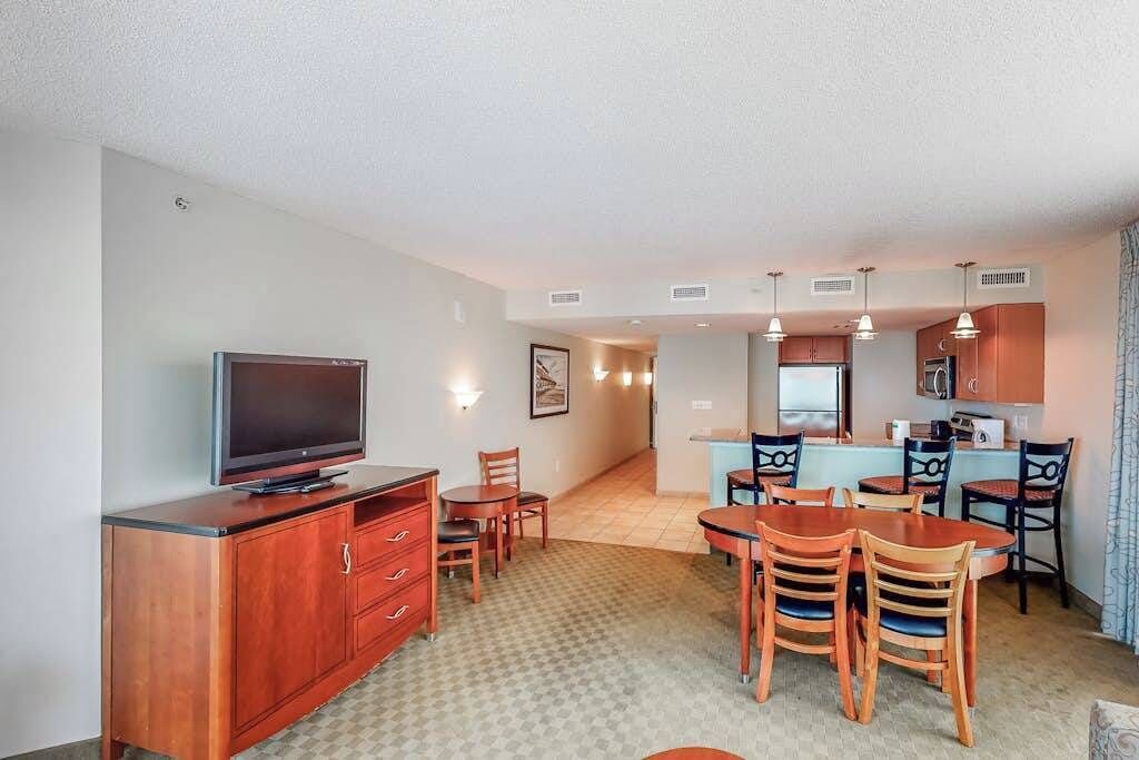 A compact living space with a kitchenette, dining area, and a television.