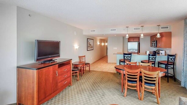A compact living space with a kitchenette, dining area, and a television. - Sandy Beach Resort 504 (Myrtle Beach)