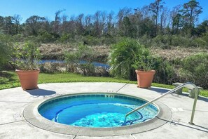 A circular outdoor swimming pool with a metal ladder, surrounded by a concrete deck. - Sea Mark Tower Unit 205 (Myrtle Beach)