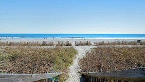 A beach path leading to the ocean with a wooden fence on one side. - Ocean Park Resort 0922/0924 Combo (Myrtle Beach)