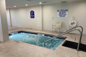 Ein Schwimmbecken mit einem Schild, auf dem steht: 'KEIN BADEMEISTER ANWEISEND' und 'BADEN AUF EIGENE GEFAHR'.