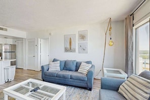 Ein modernes Wohnzimmer mit einer Couch, einem Couchtisch und Kunstwerken an der Wand.