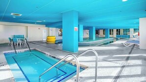 Uma área de piscina com várias pistas de natação, um vestiário e uma área de estar com cadeiras.