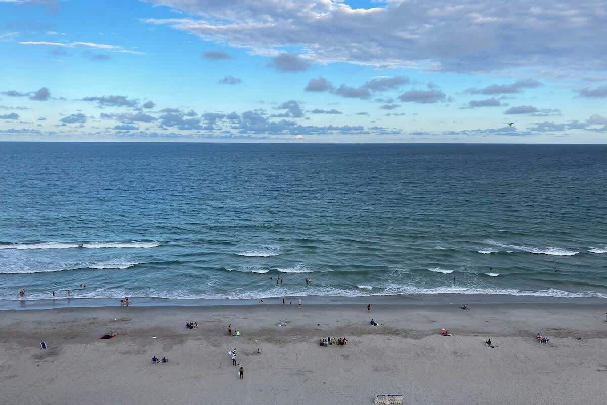 A beach with a view of the ocean and a clear sky.