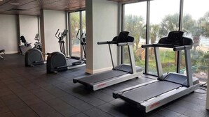 A gym with treadmills, ellipticals, and weight machines. - Sandcastle South 1509 (Myrtle Beach)