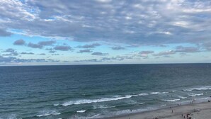 A beach with waves, people, and a cloudy sky. - Sandcastle South 1509 (Myrtle Beach)