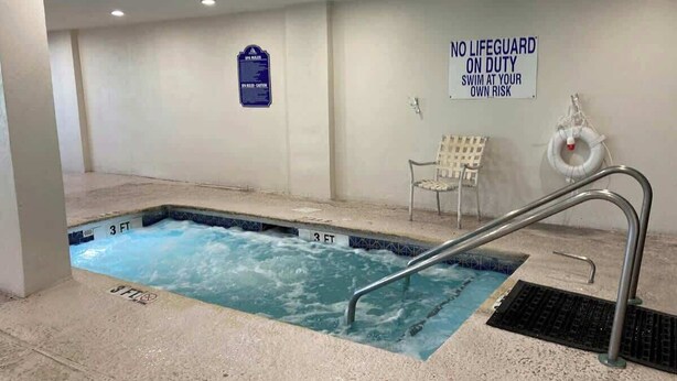 A swimming pool with a sign stating 'NO LIFEGUARD ON DUTY' and 'SWIM AT YOUR OWN RISK.' - Sandcastle South 1509 (Myrtle Beach)