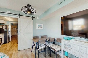 A dining area with a wooden table and chairs, a white cabinet with drawers, and a ceiling fan. - Sandtrap at the Verandas (North Myrtle Beach)
