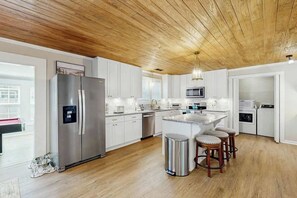 A modern kitchen with a stainless steel refrigerator, a microwave, and a sink. - Coastal Retreat on Bay Street (North Myrtle Beach)