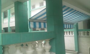 A multi-level interior with teal-colored columns and white balustrades.