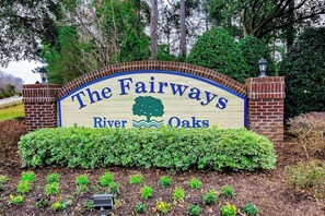 A sign with the text 'The Fairways River Oaks' surrounded by greenery and brick pillars. - River Oaks Unit 25A Condo (Myrtle Beach)