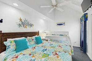 A bedroom with a bed, a ceiling fan, wall art, and a window with curtains. - Lakefront Retreat at Litchfield by the Sea (Pawleys Island)