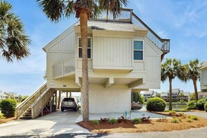 A two-story house with a balcony, a staircase, and a car parked in front. - Lakefront Retreat at Litchfield by the Sea (Pawleys Island)
