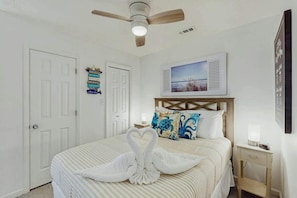 A hotel room with a bed, a ceiling fan, a nightstand, and a wall-mounted picture. - La Mirage Unit 402 Condo (Myrtle Beach)