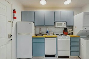 A kitchen with a white refrigerator, a microwave, a stove, and a dishwasher. - La Mirage Unit 402 Condo (Myrtle Beach)