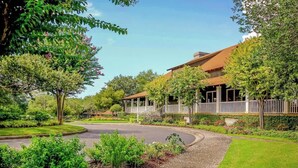 A residential property with a curved driveway, a covered porch, and a well-maintained garden. - Yacht Club Villas 2-702 (North Myrtle Beach)
