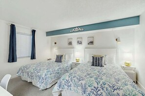 A hotel room with two beds, a desk, and a window with curtains. - Verandas Unit 407 Condo (North Myrtle Beach)