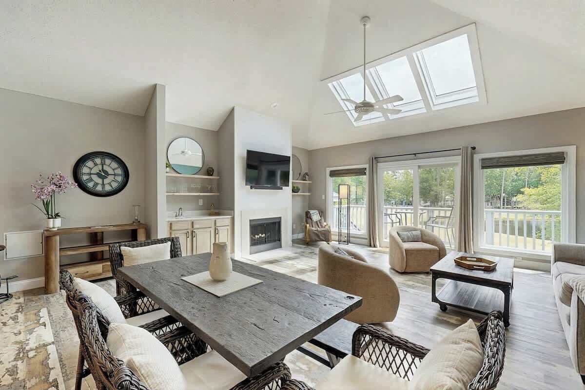 A spacious living area with a dining table, sofas, and a fireplace.