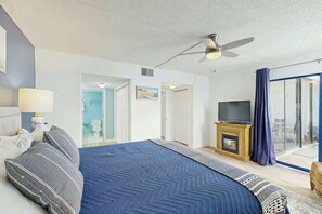 Ein Hotelzimmer mit Bett, Fernseher, Kamin und Blick durch eine Glastür.