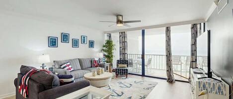 A modern living room with a sofa, coffee table, and a view to the outside.
